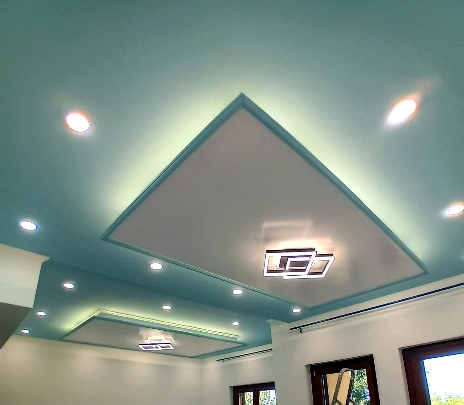 Controsoffitto moderno con illuminazione integrata e volumi geometrici